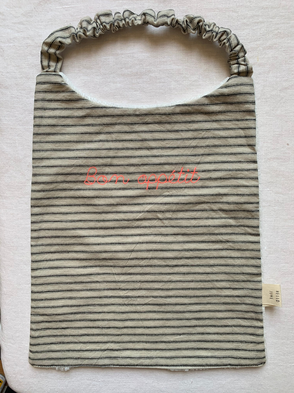 Grand bavoir cantine en lin lavé écru rayures anthracites broderie "Bon appétit" rose fluo douillette blanche  élastiqué au cou