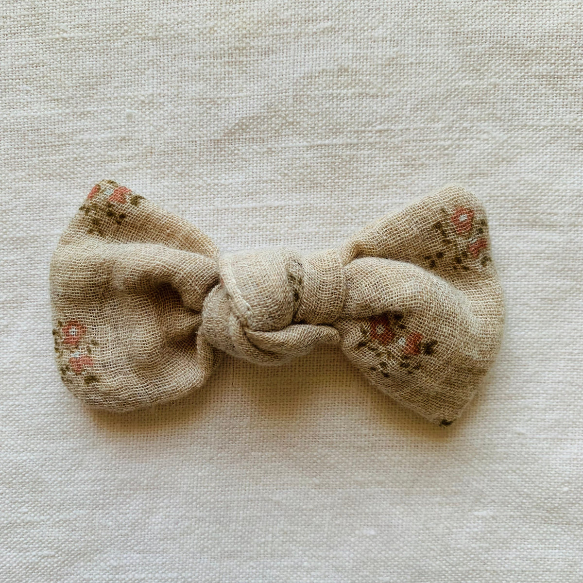 barrette en forme de nœud en gaze de coton beige et fleurs 